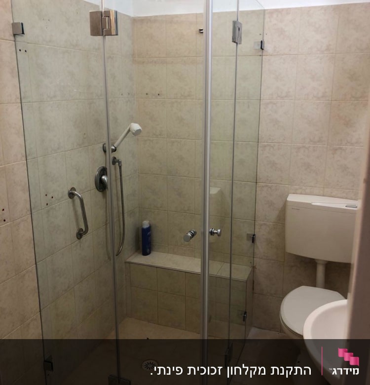 מקלחון זכוכית עם ראש מקלחת ומוצר טיפוח